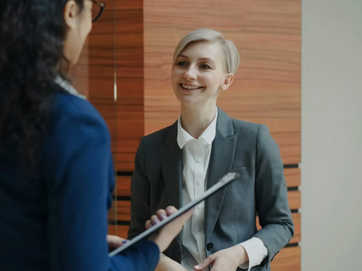 Two colleagues talking at the front of house, one holding a tablet